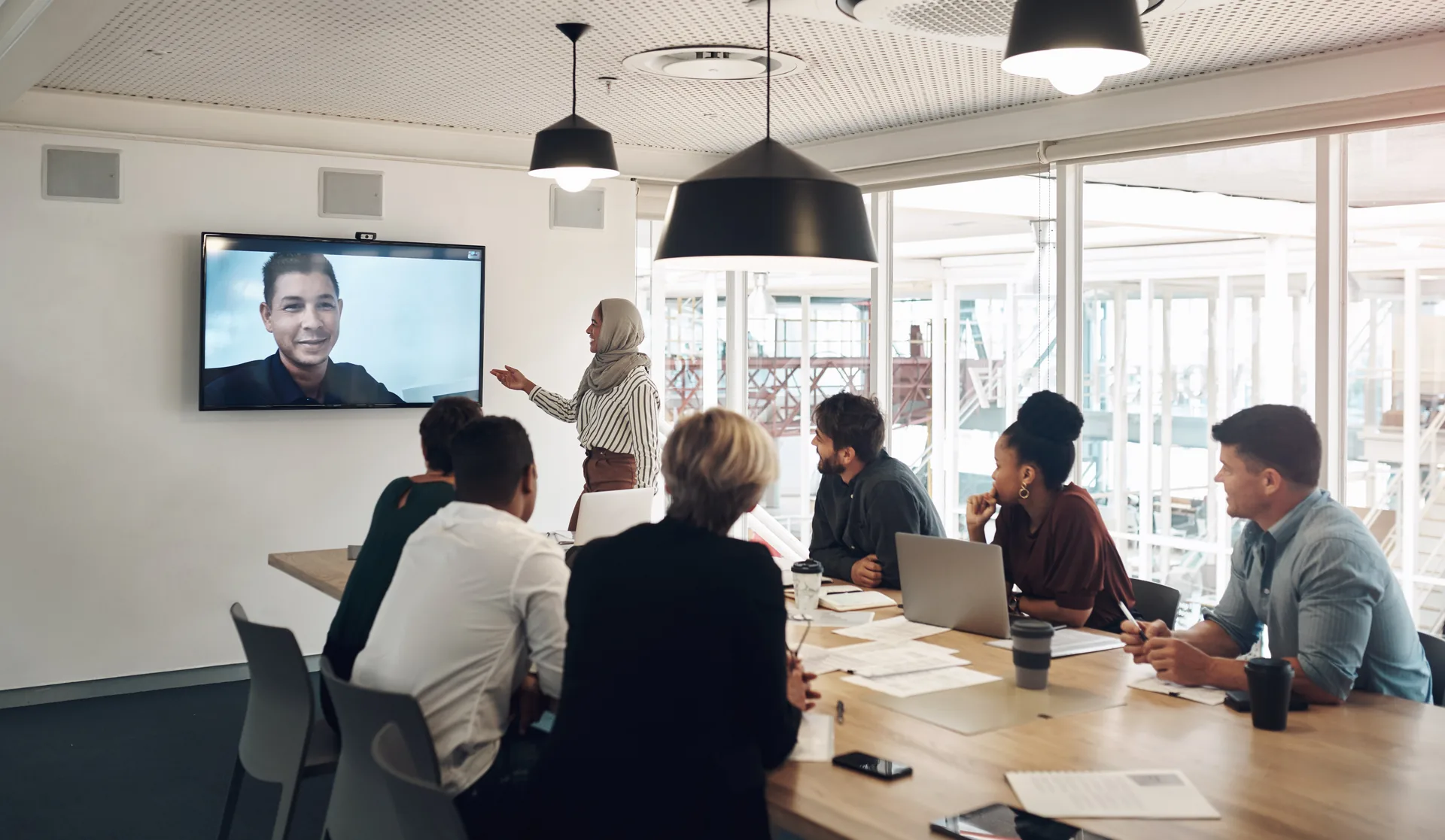 Team aziendale collegato in videoconferenza con un collega remoto